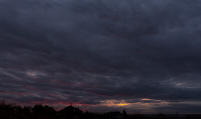 Landscape at sunset. Tragic gloomy sky. Panorama. Crimson twilight.
