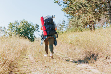 Rear view of an overweight female hiker, challenging stereotypes and embracing the hiking lifestyle