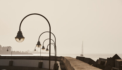 Lanterns on the promenade against the background of the sea. - Powered by Adobe