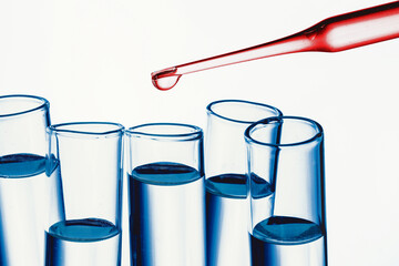 Virus vaccine research laboratory background. Red fluid pipette drop into glass flask. Blood color test transparent liquid. Empty copy space epidemic background. Covid-19 coronavirus spread texture.