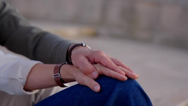 Closeup of unrecognisable romantic couple holding hands. Trust and love concept.
