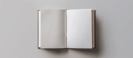 Design concept showing a white notebook from a top view, with blank pages opened, turned, and flipped on a gray background for a mockup. The image is a real photograph, not a . - obrazy, fototapety, plakaty
