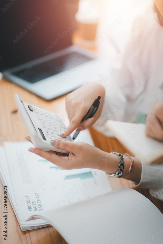 Poster close up of a business professional using a calculator for financial analysis over important documen