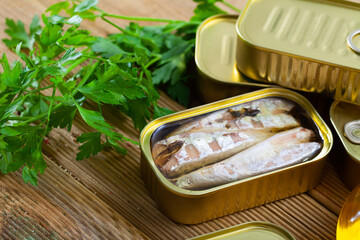 Canned seafood, headless mackerel fish preserved in oil on wooden table - obrazy, fototapety, plakaty