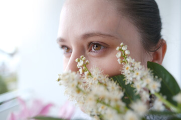 close up part of woman's face in flowers, beautiful girl 30 years old, brown eyes looking to side,...