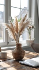 A vase with dried grass on a table next to an ipad, AI