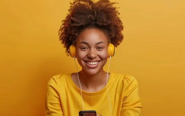 A woman with curly hair is wearing headphones and smiling