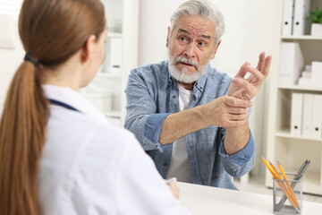 Arthritis symptoms. Doctor consulting patient with wrist pain in hospital