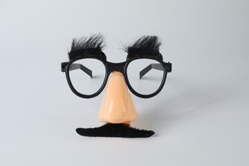 Funny mask with fake mustache, nose and glasses on light grey background