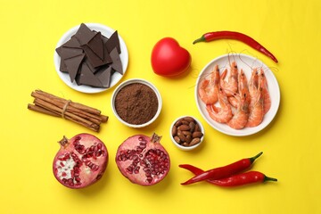 Natural aphrodisiac. Different products and heart model on yellow background, flat lay