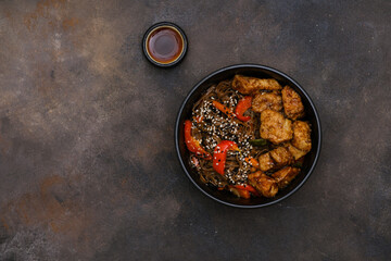 Fried Udon with Chicken and vegetables on dark brown background. Top view. Asian food.