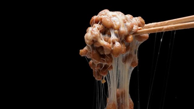 糸を引く納豆の黒背景4Kスローモーション動画