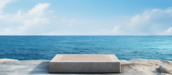 Rugged concrete block perched on a rough boulder overlooking the vast expanse of the ocean under a clear blue sky