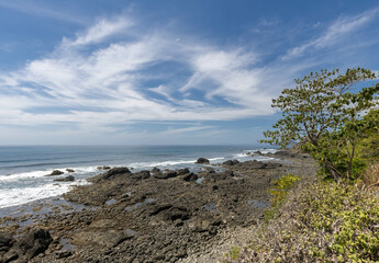 Fototapeta na wymiar Beautiful Pacific Ocean and blue sky with swirling clouds near Jaco Costa Rica in dry season