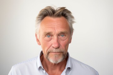 Portrait of a senior man with grey hair and blue eyes.