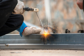 Men hands wear protective glove Hot flame metal work cutting fire iron workshop. Locksmith use...