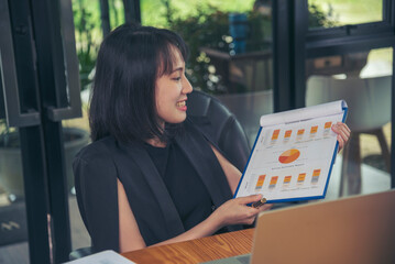 Asian businesswoman vdo call conference telecommunicate office desk. Women show Graph business report online meeting. Freelance women using laptop home office technology. Businesswoman online meeting