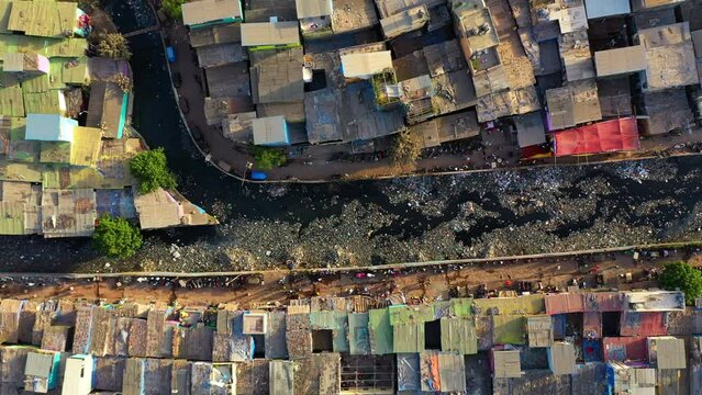 Birds eye drone shot over a trash in a waterway, in middle of poverty in India