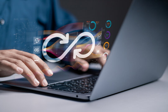 DevOps software development concept. IT operations, high software quality and software development. Agile programming development. Businessman use laptop with DevOps icon on virtual screen.