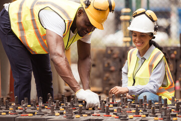 Railway technicians worker in safety vest and helmet inspect the battery in the train workshop.