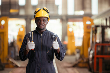 Portrait of railway technician in uniform and safety helmet working on train repair station