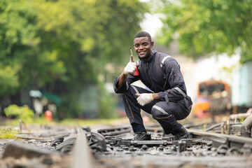 Portrait of a railway engineer on the tracks of a train in station platform.