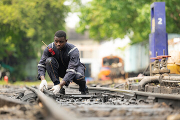 Portrait of a railway engineer on the tracks of a train in station platform.