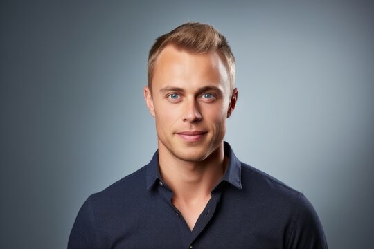 Handsome young blond man in blue shirt. Studio shot.