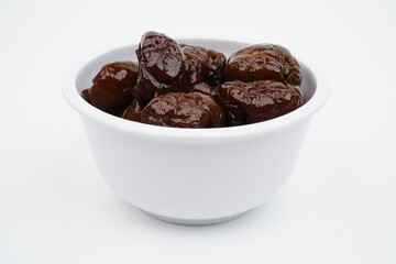 Sweet dried prunes in a white bowl Isolated Background