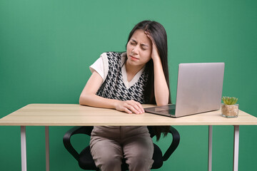 Frustrated woman feeling tired or worried about problem while working on laptop at the table