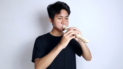 young Asian man, funny moment, happy and active, gesturing playing the flute upside down