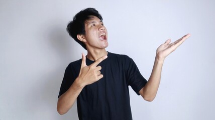 young asian man excitedly gesturing right hand pointing left palm