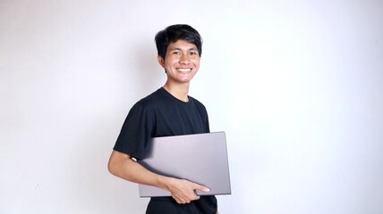 young asian man happy holding laptop