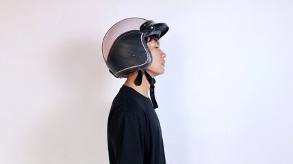 Side view of a young Asian man wearing a helmet