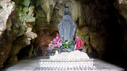 Black statue of the Virgin Mary in the grotto of Tritis attracts many pilgrims. Smiling face of...
