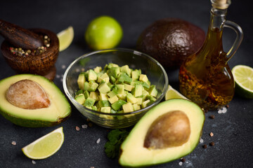 Chopped avocado in glass bowl and avocado Halves