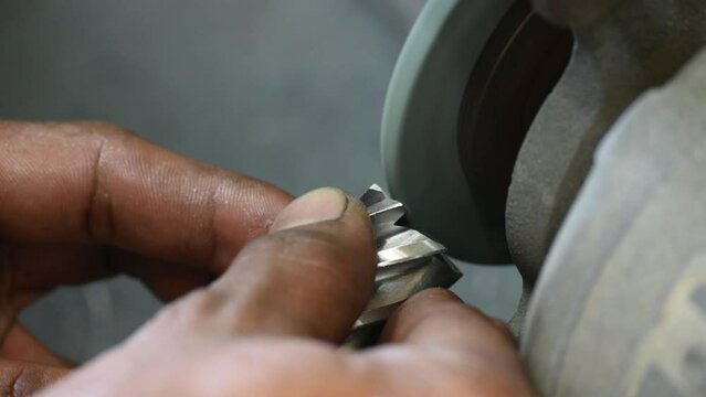 Close up scene manual tool regrind process with the abrasive wheel.