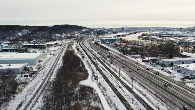 The snowy e45 in alelyckan, gothenburg with traffic, industry areas, aerial view