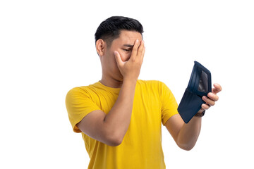 Sad Asian young man looking at his empty wallet, covering his face with hand, no money isolated on white background