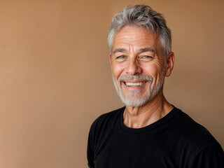 Obraz premium portrait of a Man in his 60's looking handsome and happy and smiling on a beige background, conceptual image for senior dating apps