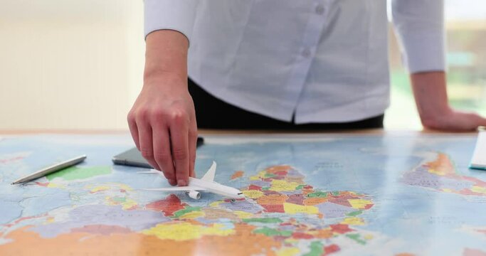 Woman moves model of airplane tracing possible flight route