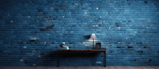 A blue brick wall serves as a background for a table and a lamp placed in front of it
