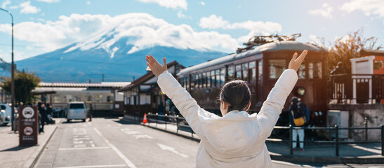Woman tourist with Fuji Mountain at Kawaguchiko train station, happy Traveler sightseeing Mount Fuji in Yamanashi, Japan. Landmark for tourists attraction. Japan Travel, Destination and Vacation - obrazy, fototapety, plakaty