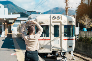 Woman tourist with local train at Otsuki station during trip to Kawaguchiko station, happy Traveler sightseeing Mount Fuji in Yamanashi, Japan. Japan Travel, Destination and Vacation conccept