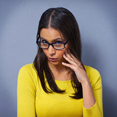 Woman, surprise and glasses in studio portrait, secret and information on drama by blue background....