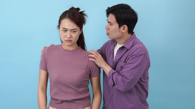Young Asian couple on blue background