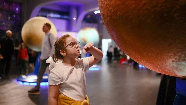  child studies an exhibit in a museum, a planets , meteorite. High quality 4k footage