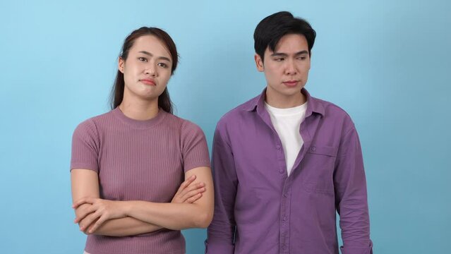 Young Asian couple on blue background