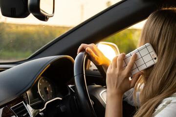 Happy young woman speaking by mobile phone while driving car. Business woman talking phone call in...
