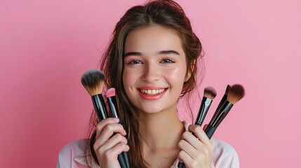 Beautiful young girl  standing isolated over pink background, holding makeup products.